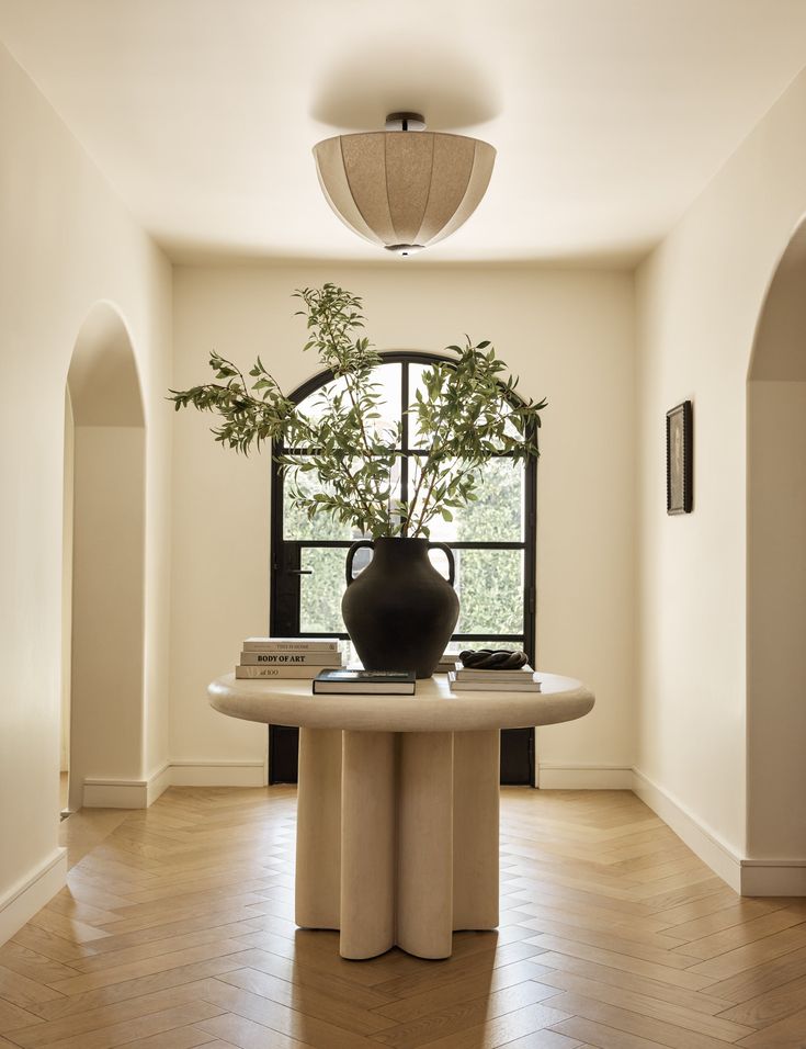Entry hall of a North Texas home with an arched opening and herringbone floors